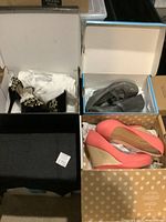 Three pairs of women's dress shoes in their boxes: black stilettos with studded detail, gray Mary Jane wedges, and coral espadrille wedges