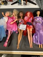 Lot of 5 fashion dolls from Barbie and Disney Princess series including Elsa, Aurora, Ariel, Rapunzel, and one Barbie doll, showing front view of the dolls laid out.