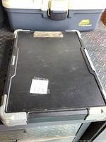 Closed view of black Maxxima tool case with gray corners and metal latch, showing top surface and front.