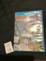 Front and back photos of Minecraft: Wii U Edition game case for Wii U with Super Mario Mash-Up sticker on the front cover. The case shows visible damage.