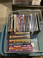 Topdown photo of about 25 DVDs in a plastic tub: Includes The Simpsons, Trailer Park Boys, King Arthur, Lion King among others.