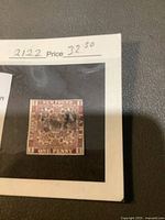 Close-up of the used Newfoundland Scott No 1 3d 1851 One Penny postage stamp, showing text, design, and cancellation marks on a protective backing.