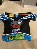 Front view of black and blue hockey jersey with logos and team number 3