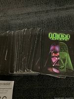 Stack of Star Wars Jedi Knights collectible trading cards showing card backs with green grid design and Darth Vader image