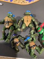 Four Teenage Mutant Ninja Turtles action figures: three Leonardo figures and one Donatello figure in various sizes with no accessories.