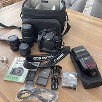 Overall lot with camera, lenses, flash, bag, charger, cables, manual disk and accessories