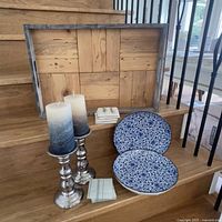 Wide view showing all items including wooden tray, candlesticks with candles, decorative plates, and coasters