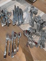 Overview of entire flatware set laid out on table showing different types of utensils.