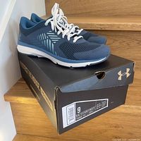 Blue Under Armour running shoes on original black box, size label visible showing size 9