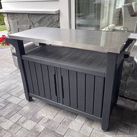 Front view showing stainless steel top and black composite storage base