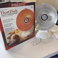 Presto HeatDish Plus Footlight heater next to original box, showing heater and packaging with product image and description.