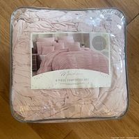 Packaged pink Mackena 8-piece queen comforter set in original plastic packaging showing branding and content information.