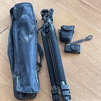 Group shot showing Velbon tripod, tripod case, Roots camera pouch, and Canon S95 camera on wooden floor