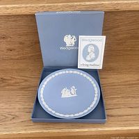 Wedgwood blue Jasperware plate with white classical relief motifs, in original Wedgwood box with pamphlet