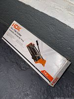 Boxed HDX manual tile cutter showing brand and model size 14 inches
