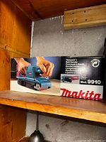 Photo of Makita 3 inch belt sander model 9910 box showing product image and model info