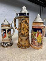Seven assorted beer steins arranged in two photos showing different angles and designs.