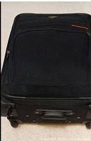 Side view of black suitcase showing wheels and handle area