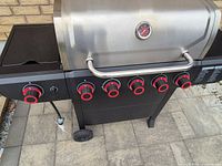 Frontal view showing six control knobs and side burner control knob