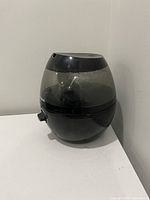 Side view of Honeywell black humidifier showing the dial control knob and transparent water tank.