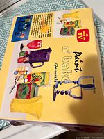 Top view of yellow box with Paint n Bake branding showing painted examples and product features.