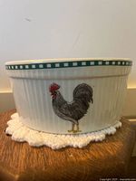 Ceramic baking pot with side featuring black and grey rooster with red comb and yellow feet.