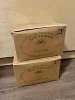 Two cardboard boxed Eco Pioneer soap bars, one labeled Pure Borax and the other Pure Washed Soda, stacked vertically with visible wear.