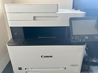 Printer front and partial top view showing control panel, paper feeder and Canon logo