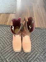 Top view showing the pink leopard print interior lining and brown leather exterior of the boots.