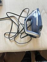 Top side angle of Tefal Durilium Technology steam iron showing blue and silver body with cord and ergonomic handle.