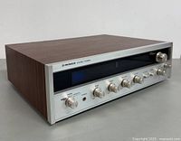 Front angle view of Pioneer ES-2000/K AM/FM stereo receiver showing wood casing and control panel.