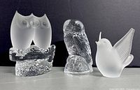 Three Swedish glass bird paperweights shown from front with dark background