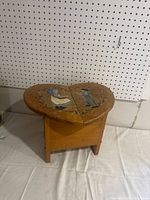 Photo of wooden heart-shaped stool showing painted Amish children on top and overall shape.