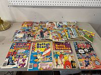 Overview of 22 Archie Comics including Betty & Veronica, Betty's Diary, and P.E.P. titles spread on a table.