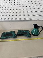 Photo showing the pitcher and two trays on shelf with measuring tape in front