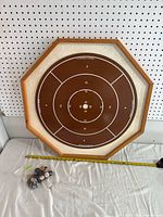 Full view of crokinole board with playing pieces and tape measure for scale.