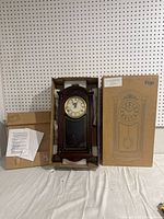 Full clock in original cardboard packaging with instructions visible.