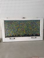 Front view of the framed marble filled window artwork with white wooden frame and metal handles.