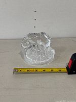 Front angle of clear glass polar bear figurine with tape measure showing approximately 3.5 inches in length.