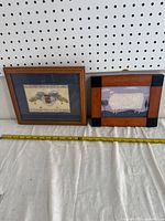 Two framed artworks, one fabric applique with house and quote in a wood frame and one sheep motif in wood frame with corner accents