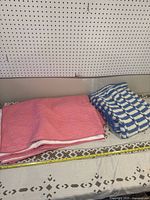 Starburst quilt and crocheted blanket folded on a table with measuring tape.