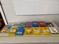 Full layout of the 10 Simpsons DVD seasons box sets along with TV Times magazine and The Simpsons DVD The Movie case.