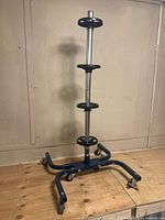 Full view of the metal tire storage rack showing four circular holders for tires and caster wheels at base.