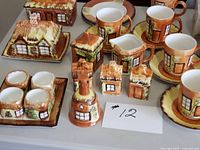 Group of Kensington Cottageware pieces including mugs on saucers, creamer, shakers, lidded dish, egg cup set