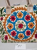 Front view of embroidered tote showing pattern and handles