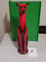 Front view of red and black glazed ceramic cat figurine