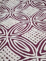 Close-up of white chenille geometric pattern on burgundy background