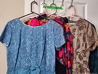 All six dresses hung on hangers for overall view