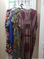 All four kaftans hanging on door for full lot view