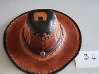 Top view of hat showing horseshoe motif, laced brim and concho